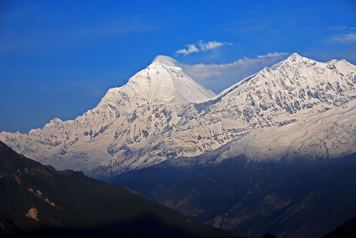 05 Dhaulagiri And Tukuche Peak After Sunrise From Kharka On Way To Mesokanto La Clouds obscured the view of Dhaulagiri at sunrise from our camp on the kharka (3460m) above Jomsom on the way to Tilicho Lake. However, the clouds dissipated after sunrise to reveal the bright white north face of Dhaulagiri and Tukuche Peak.